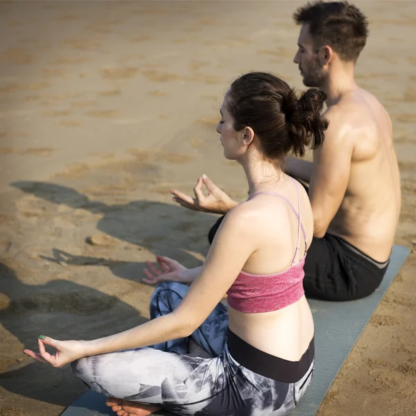 Coppia che fa yoga sulla spiaggia — Foto Stock