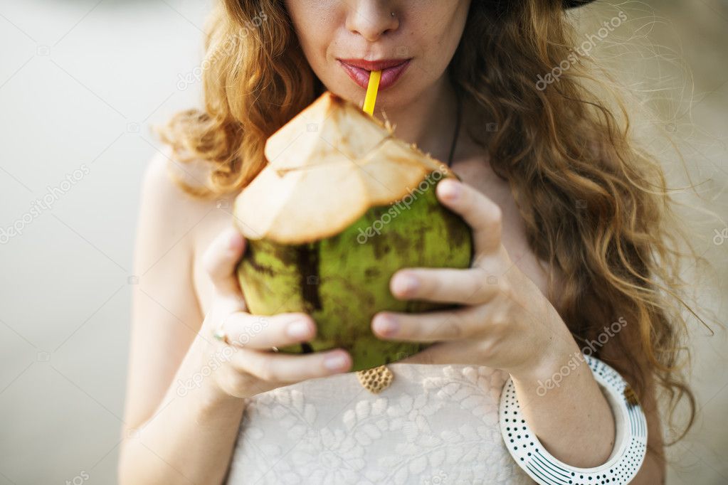 beautiful woman drinking from coconut 