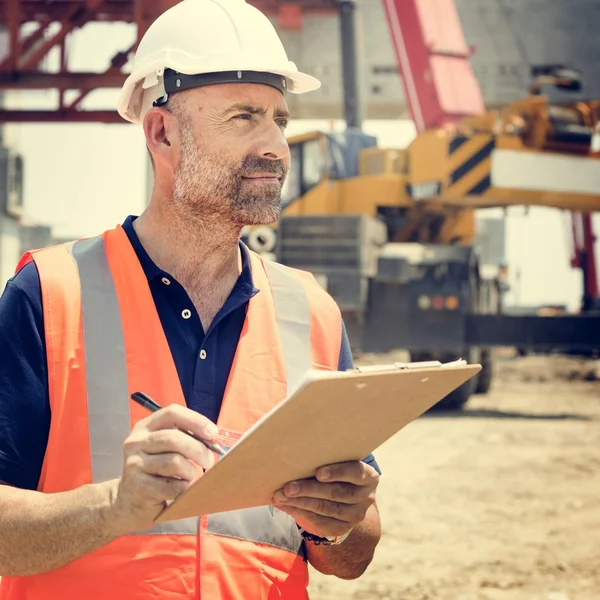 Obrero de la construcción con plan de arquitectura —  Fotos de Stock