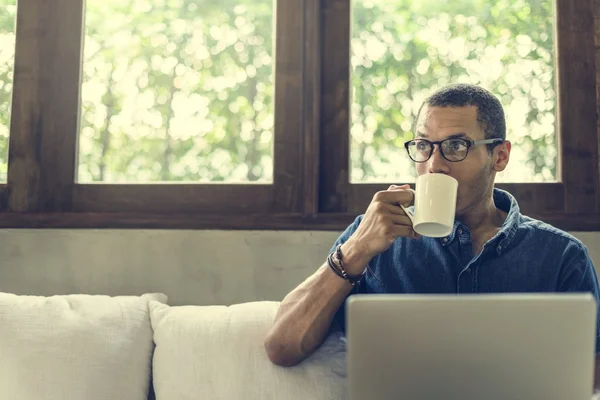 Άνθρωπος, πίνοντας τσάι και χρησιμοποιώντας φορητό υπολογιστή — Φωτογραφία Αρχείου