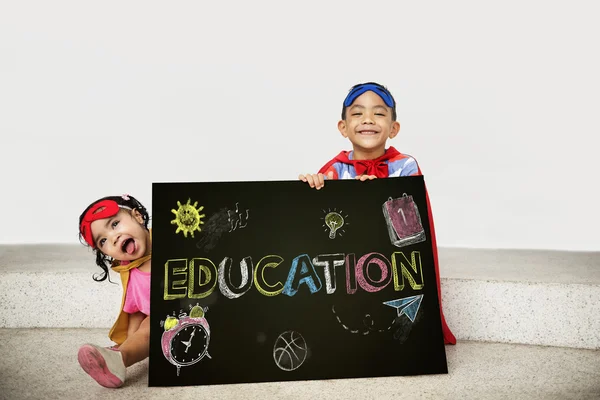 Superhéroe Niños con tabla en las manos —  Fotos de Stock