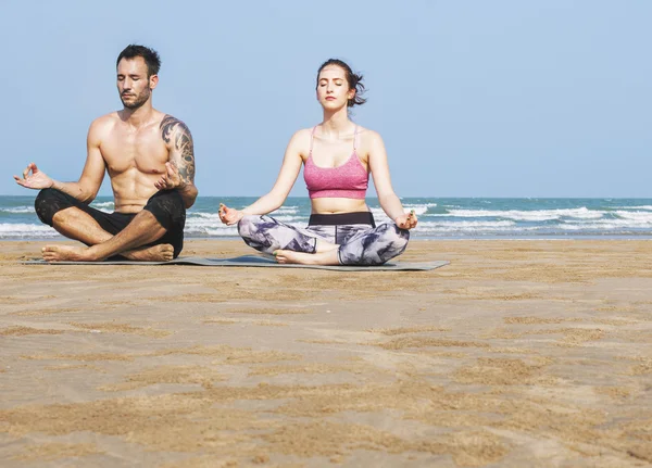 Çiftler plajda yoga yapıyor. — Stok fotoğraf