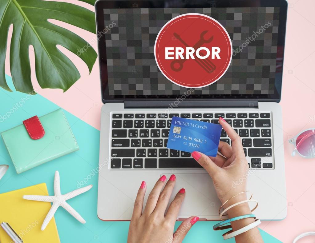 Laptop with error on monitor and hand with credit card Concept