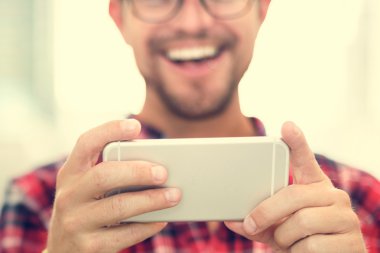 Genç adam akıllı telefon kullanıyor.