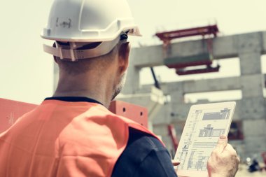 İnşaat işçisi ile mimari planı