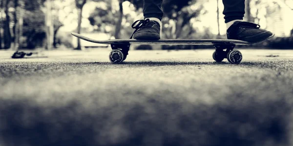 Beine in Schuhen auf Skateboard stehend — Stockfoto