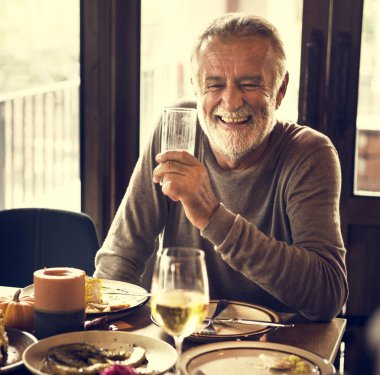gülümseyen ve cam tutan bir yetişkin adam