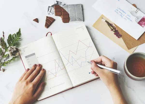 Woman making notes in diary — Stock Photo, Image