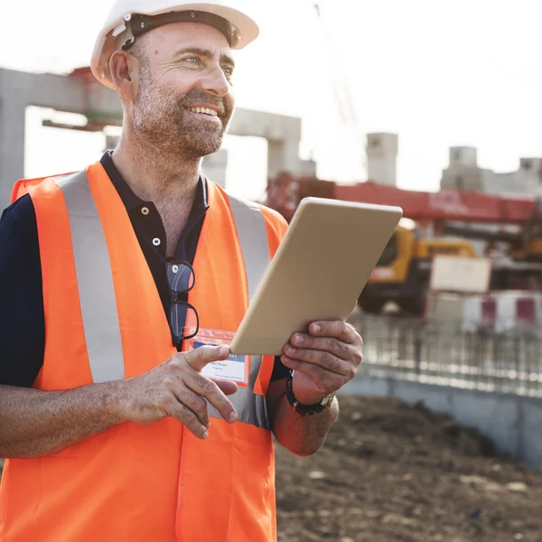 Obrero de la construcción con plan de arquitectura —  Fotos de Stock