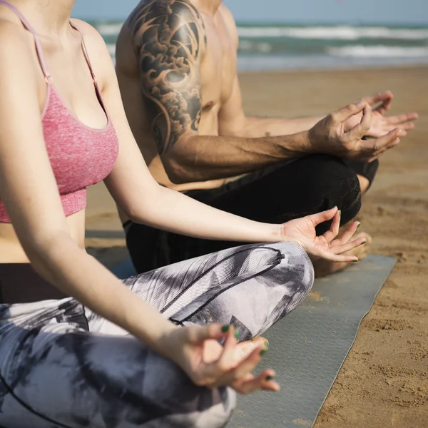 Coppia che fa yoga sulla spiaggia — Foto Stock