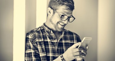 Genç adam akıllı telefon kullanıyor.