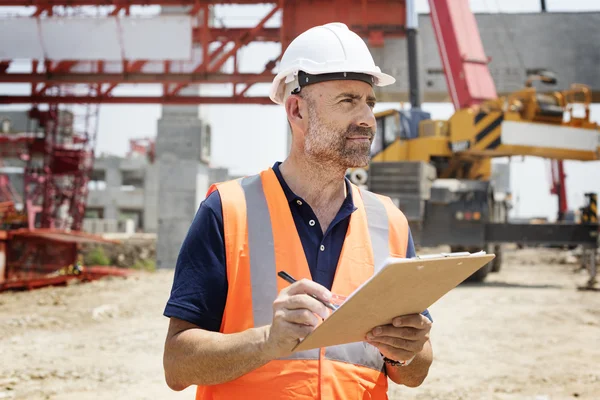 Obrero de la construcción con plan de arquitectura —  Fotos de Stock