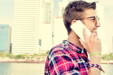 Akıllı telefonu olan genç bir adam.