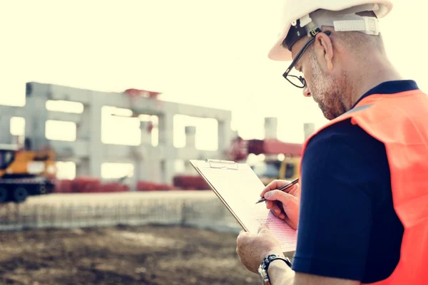 Obrero de la construcción con plan de arquitectura —  Fotos de Stock