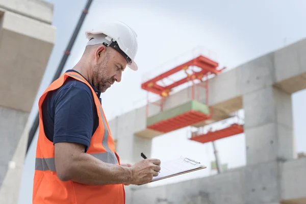 Obrero de la construcción con plan de arquitectura —  Fotos de Stock