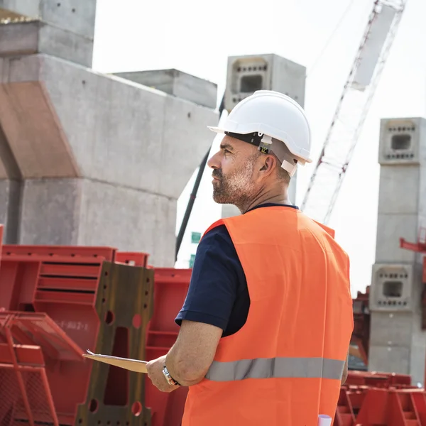 Obrero de la construcción con plan de arquitectura — Foto de Stock