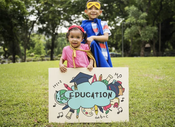 Superheld kinderen bestuur in handen — Stockfoto