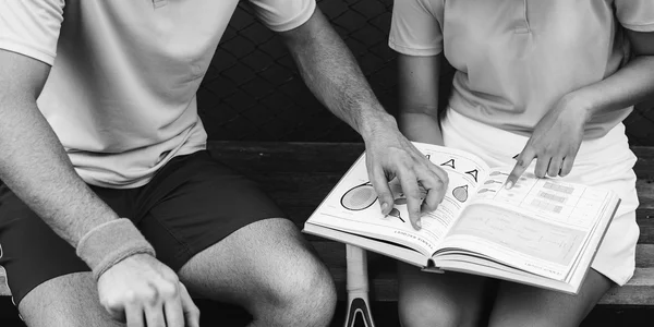 Meisje en Trainer tennis boek lezen — Stockfoto