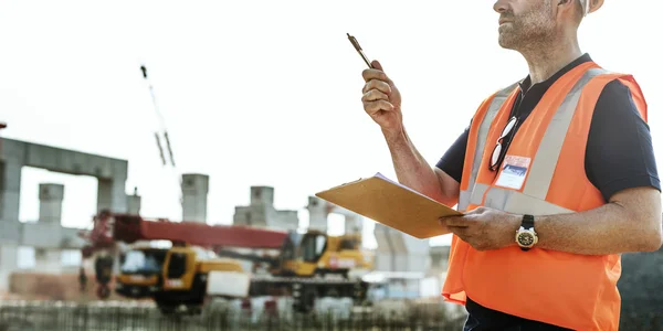 Obrero de la construcción con plan de arquitectura — Foto de Stock