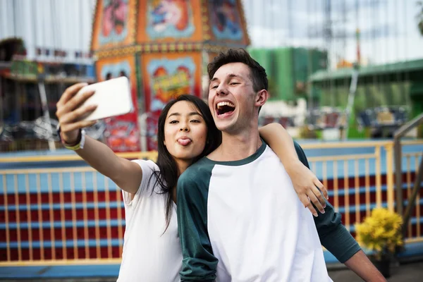Couple making selfie in amusement park — Stock Photo, Image
