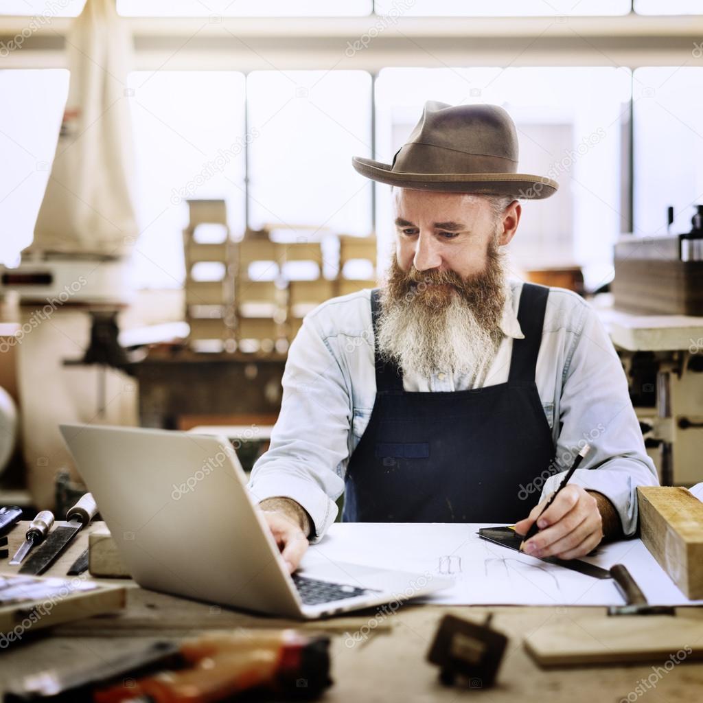 Craftsman using laptop in workshop studio