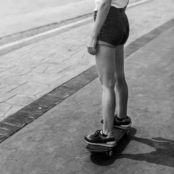 Menina em shorts montando no skate — Fotografia de Stock