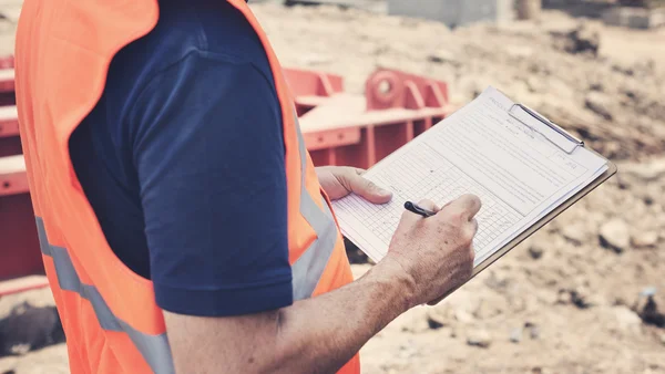 Obrero de la construcción con plan de arquitectura —  Fotos de Stock