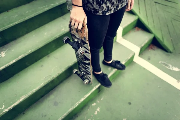 Frau steht mit Skateboard — Stockfoto