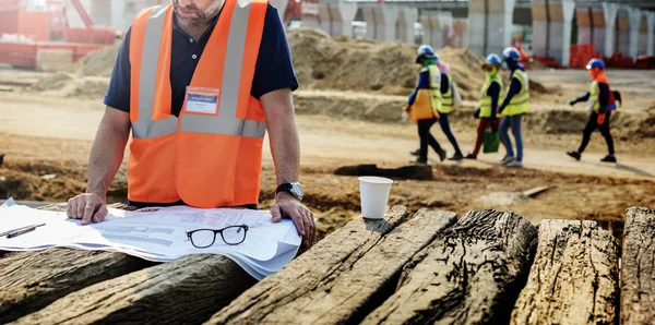 Trabalhador da construção civil com plano de construção — Fotografia de Stock