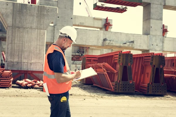 Obrero de la construcción con plan de arquitectura —  Fotos de Stock