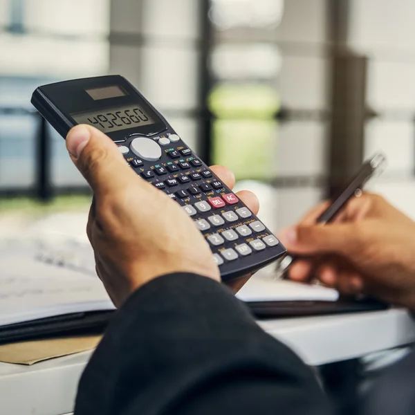 Homem de negócios contando com calculadora — Fotografia de Stock