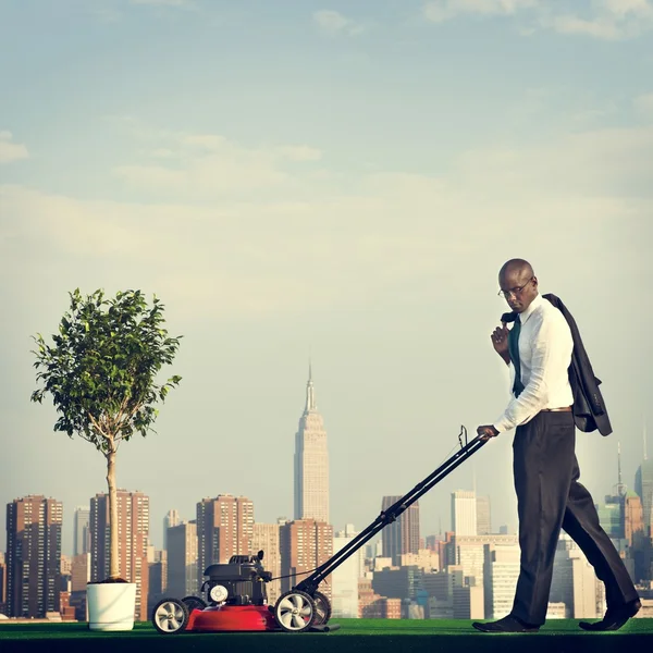 Green Businessman mowing lawn — Stock Photo, Image