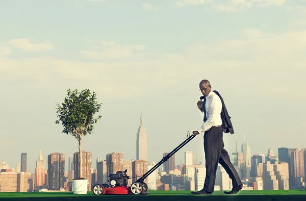 Green Businessman mowing lawn — Stock Photo, Image