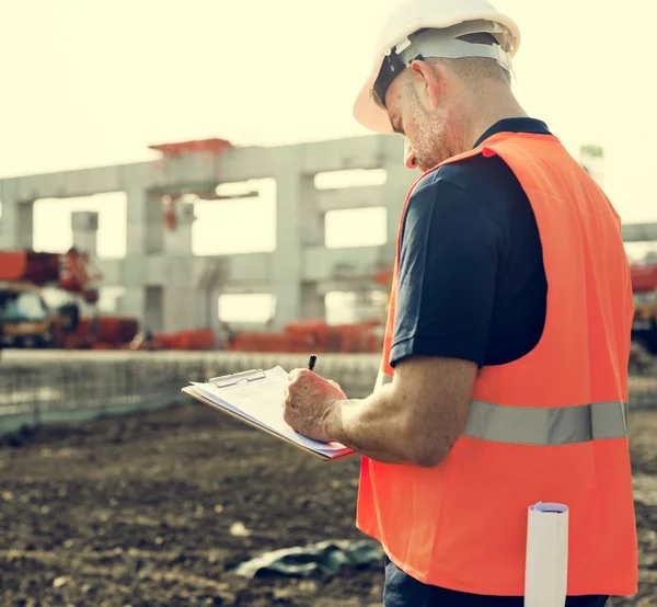 Obrero de la construcción con plan de arquitectura —  Fotos de Stock