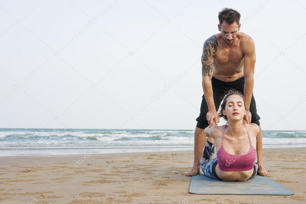 Couple doing Yoga on Beach
