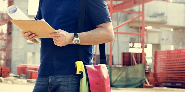 Obrero de la construcción con plan de arquitectura — Foto de Stock