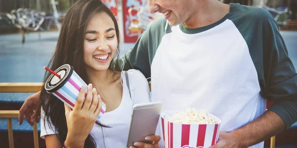 Paar benutzt Handy in Freizeitpark — Stockfoto