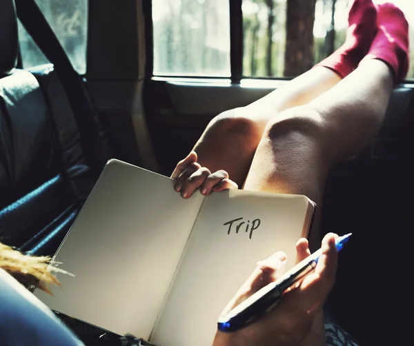 Mujer acostada en el coche, llevando diario — Foto de Stock