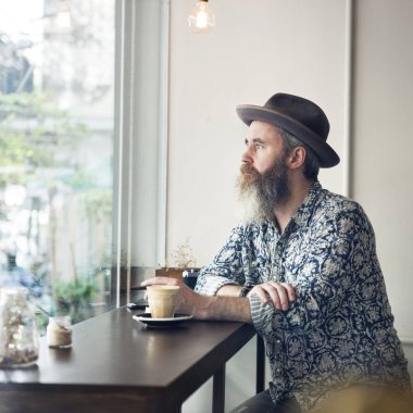 hipster adam kafede oturan şapkalı