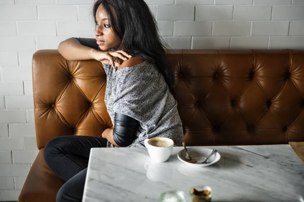 Chica sentarse en la cafetería en el sofá de cuero — Foto de Stock