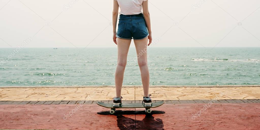 Girl in shorts riding on skateboard