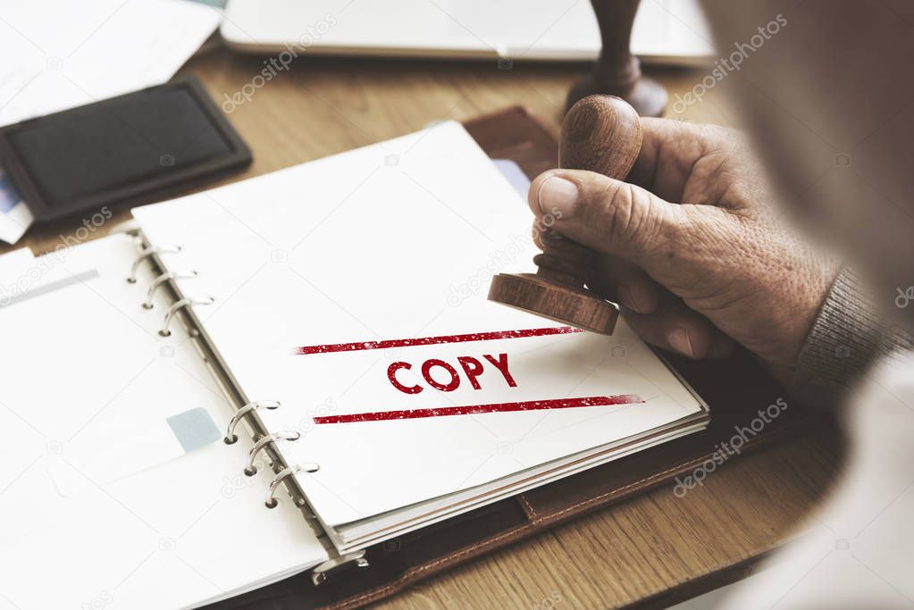 man putting stamp on paper notebook