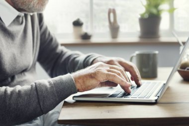 Kıdemli dijital dizüstü bilgisayar kullanan adam