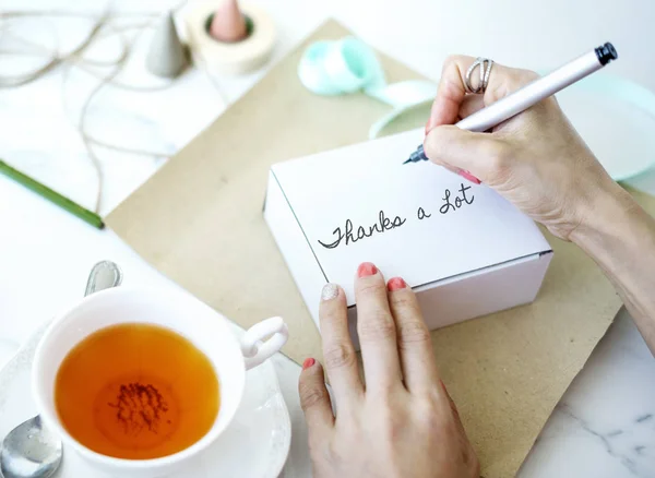 Mujer escribiendo deseos en la postal — Foto de Stock