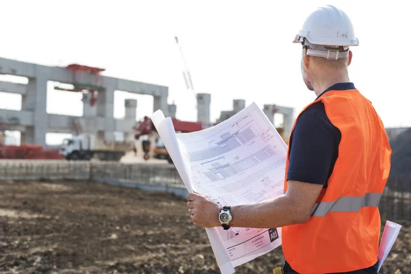 Obrero de la construcción con plan de arquitectura —  Fotos de Stock