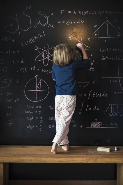 Kleines Mädchen zeichnet auf Tafel — Stockfoto