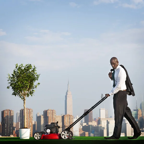 Green Businessman mowing lawn — Stock Photo, Image