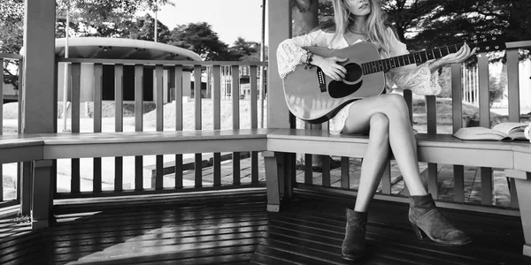 Blonde vrouw Playing akoestische gitaar — Stockfoto