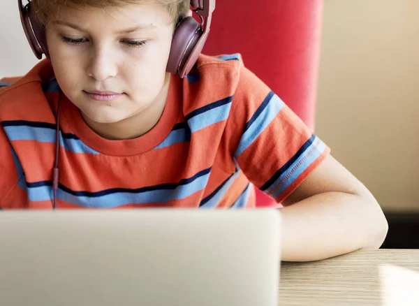 Αγόρι ακουστικών που χρησιμοποιούν φορητό υπολογιστή — Φωτογραφία Αρχείου