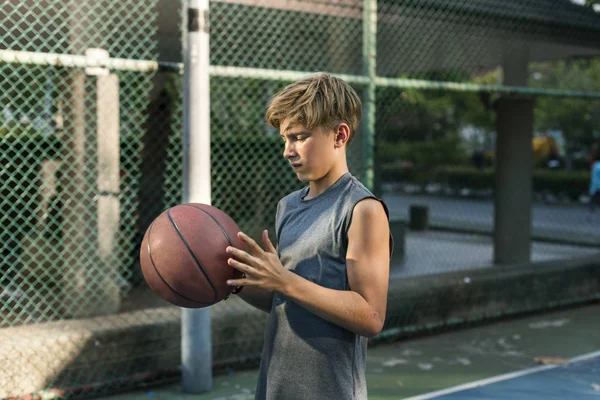 Pojken håller basket boll — Stockfoto